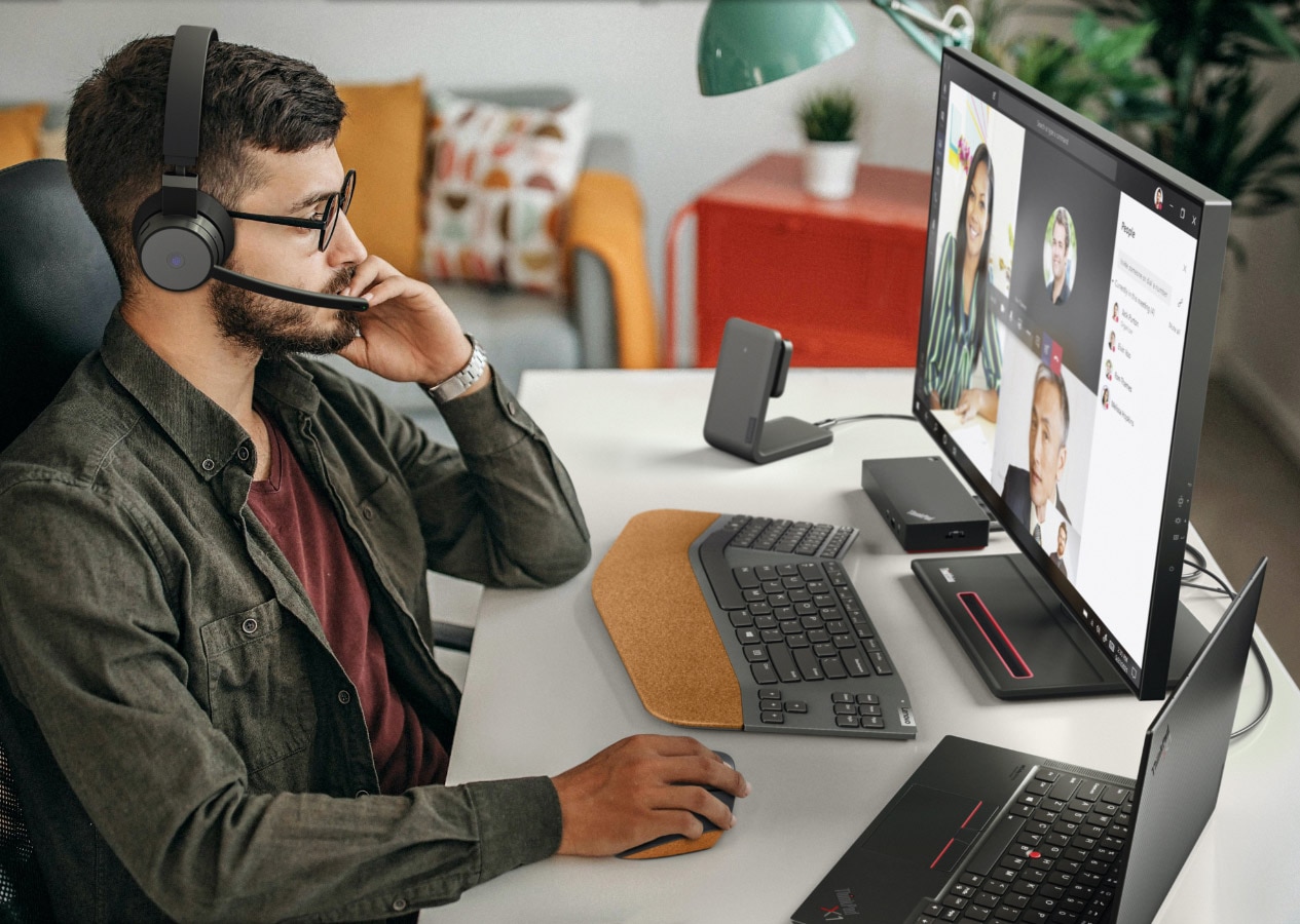A man wearing headsets and having an online meeting